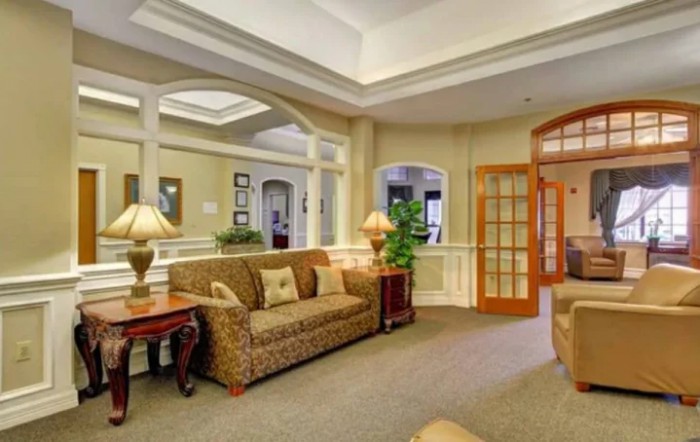 A cozy living room with elegant decor, featuring a patterned sofa, lamps, and glass doors.