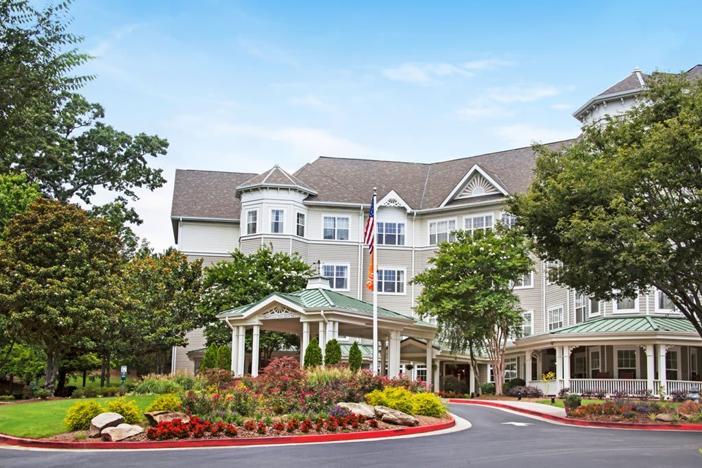 A beautifully landscaped hotel with a welcoming entrance and an American flag flying.