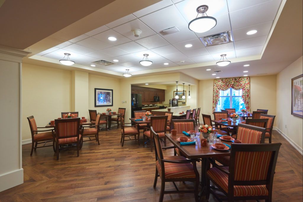 A cozy dining room with wooden tables and chairs, warmly lit and decorated.