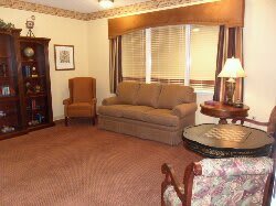 Cozy living room with a sofa, armchair, and warm lighting.