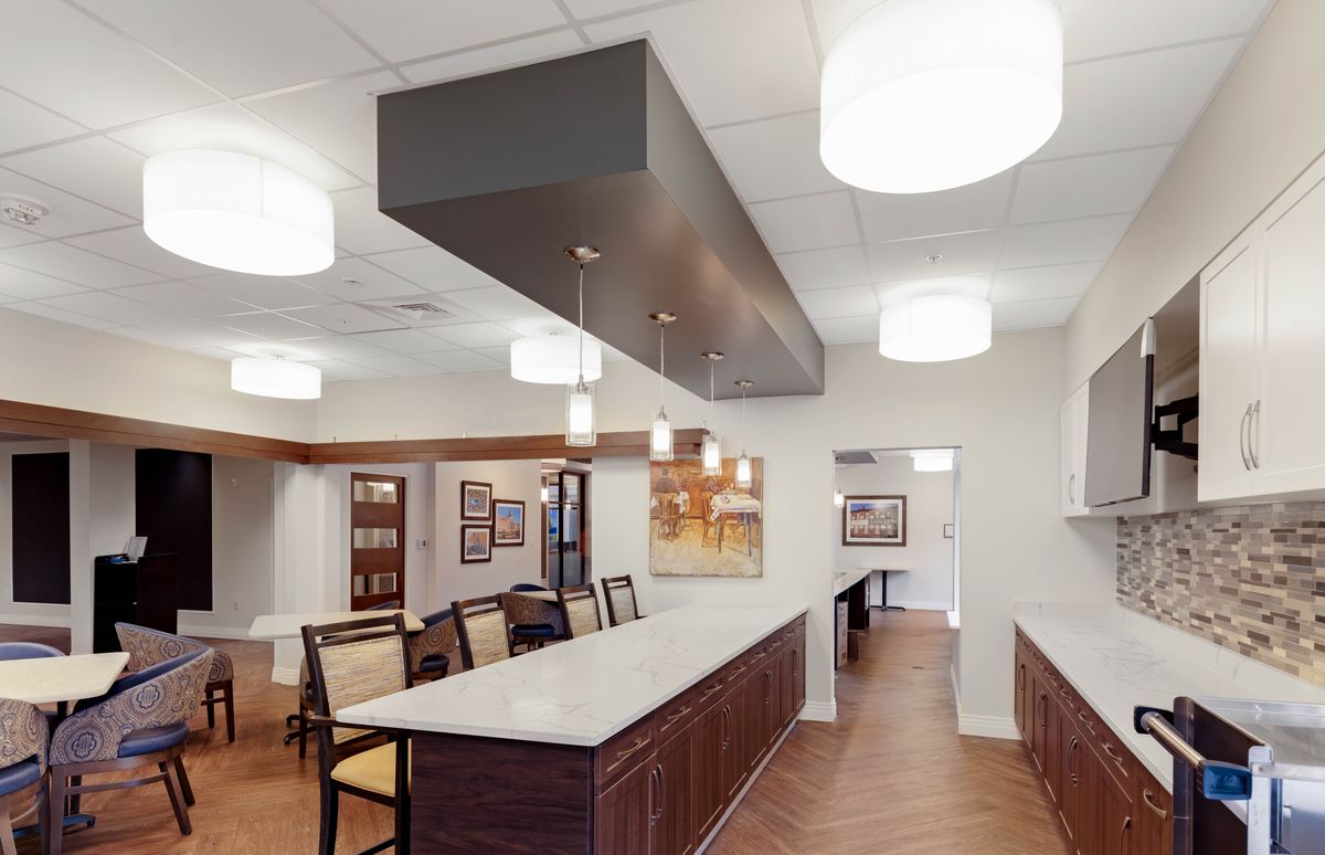 A modern dining and kitchen area with contemporary lighting and art decor.