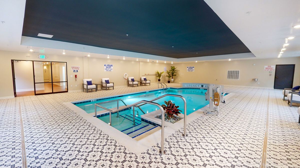 An inviting indoor swimming pool with a tiled floor and seating area, perfect for relaxation.