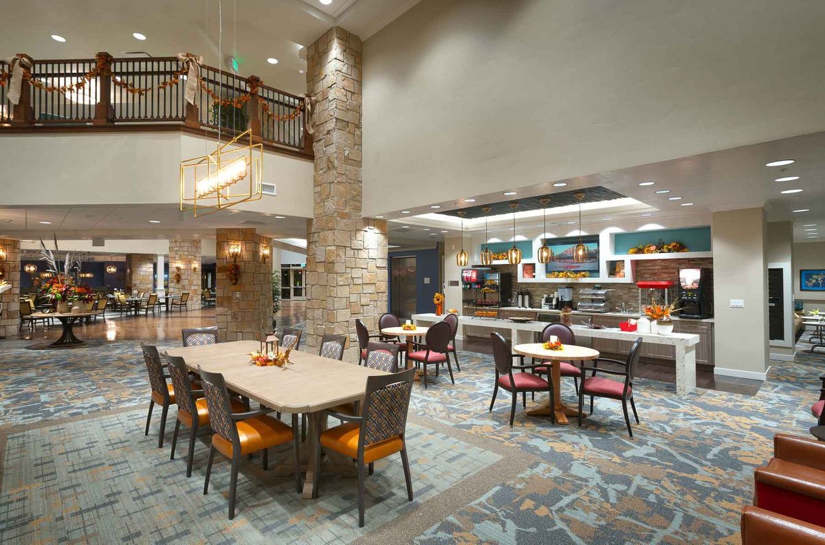 A modern dining area with tables and chairs, featuring stylish lighting and decor.