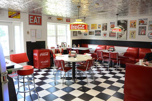 A vibrant retro diner with a classic checkered floor and nostalgic Coca-Cola decor.