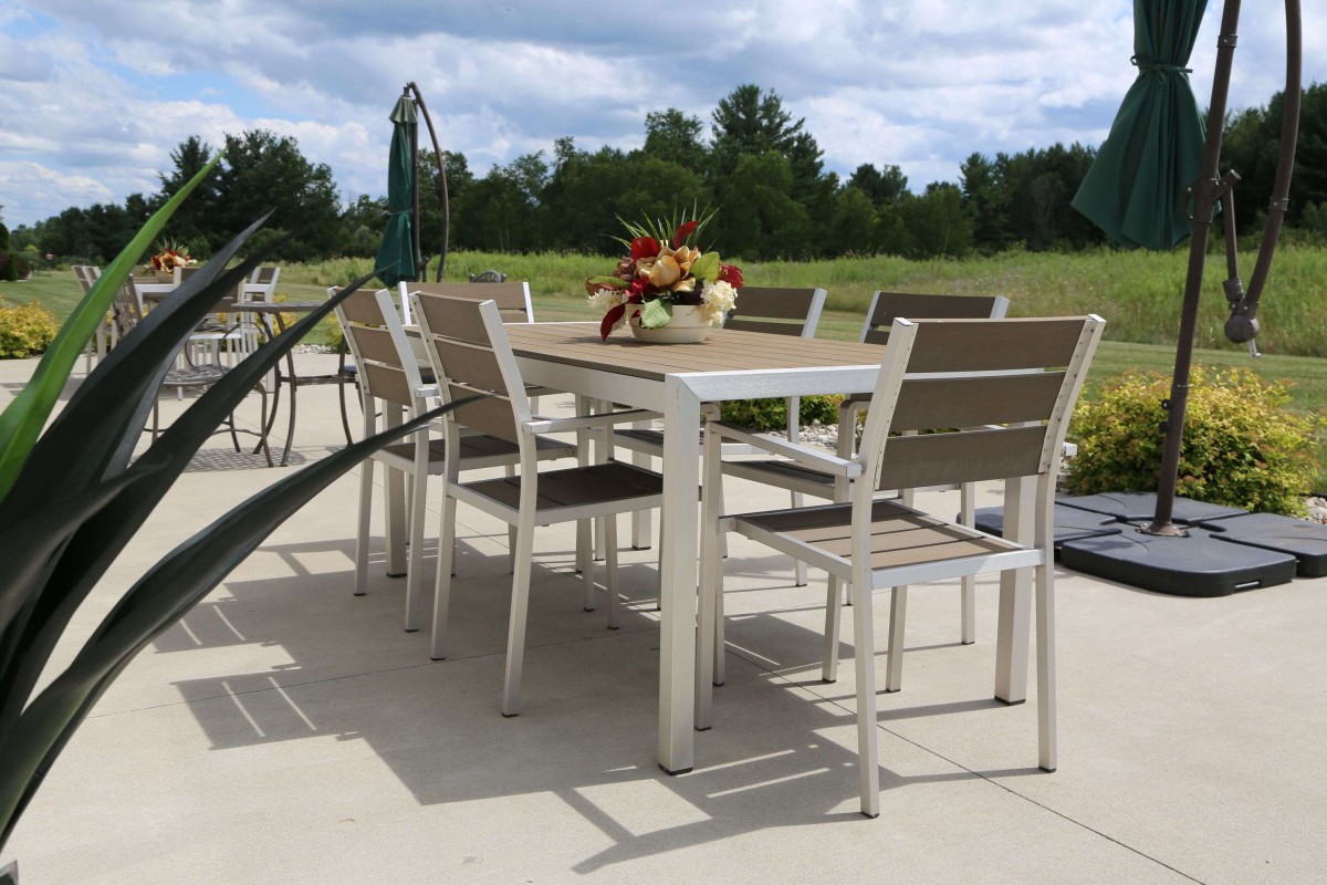 An outdoor patio set with a table and chairs, surrounded by greenery.