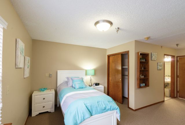 A cozy bedroom with a single bed and soft blue bedding.