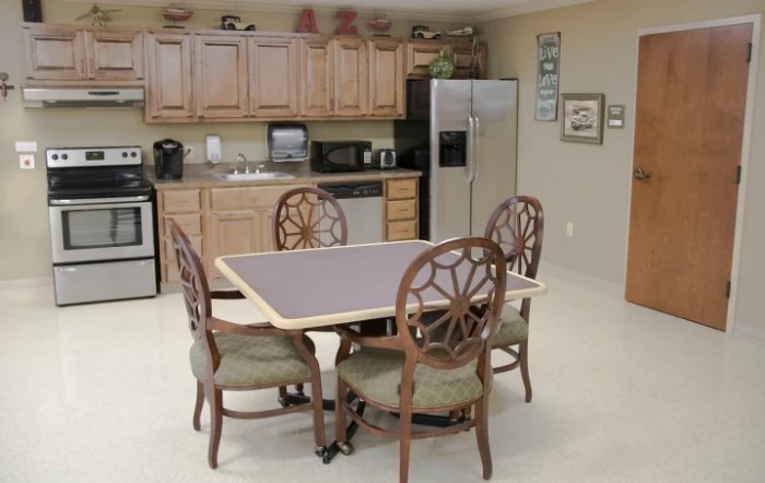 A cozy kitchen and dining area with a table and chairs, wooden cabinets, and modern appliances.