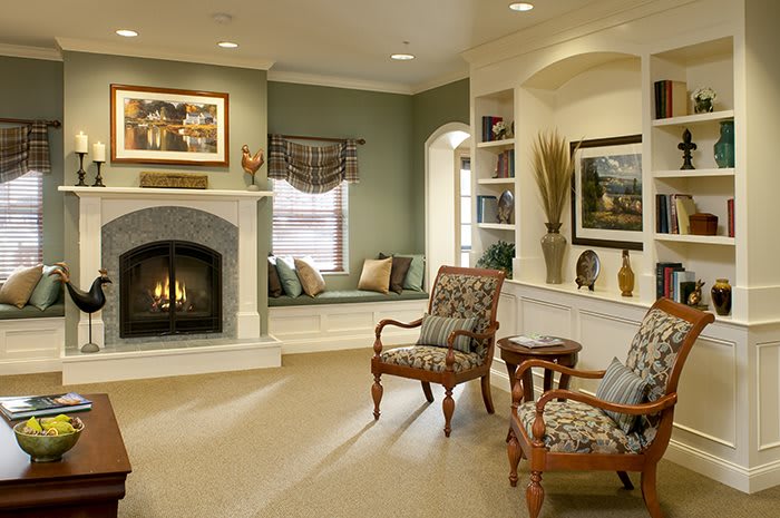 A cozy traditional living room with a fireplace, comfortable armchairs, and elegant decor.