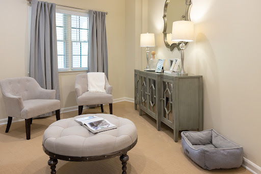 A cozy and elegantly designed living room featuring comfortable seating, a stylish ottoman, and tasteful decor.