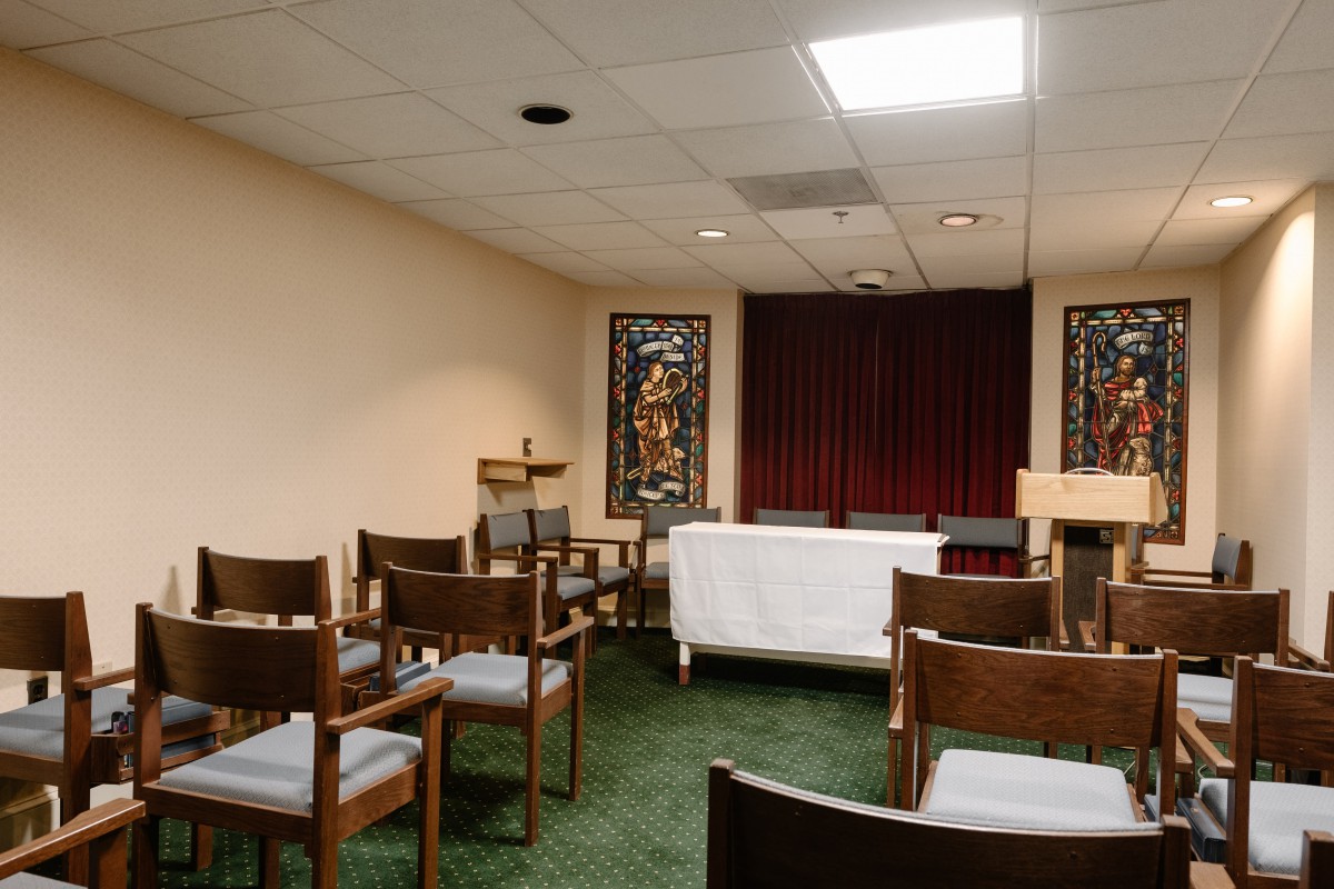 A small chapel with rows of chairs facing an altar.