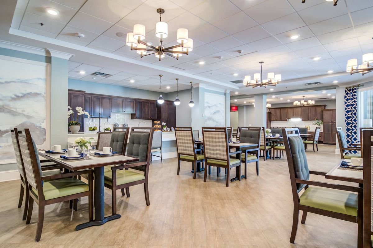 A well-lit dining area with tables and chairs arranged neatly.