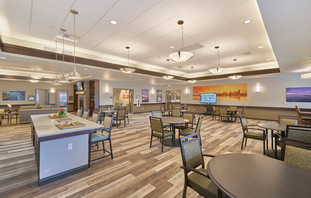 A modern dining area with neatly arranged tables and chairs, featuring elegant lighting fixtures.