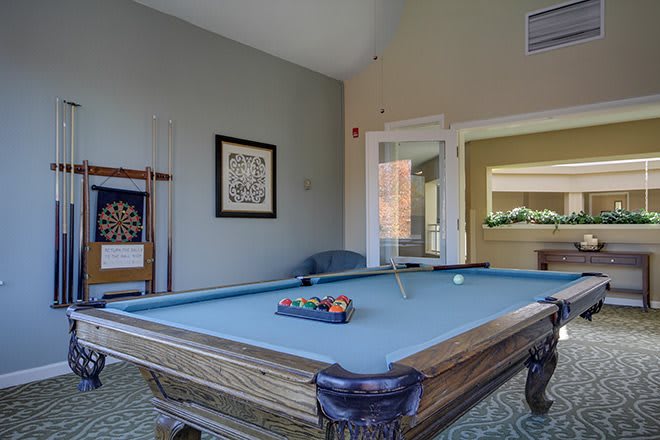 A cozy game room featuring a billiards table and darts board.