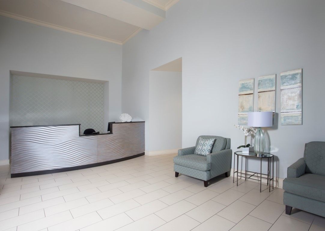 A modern, minimalist reception area with a desk and comfortable seating.