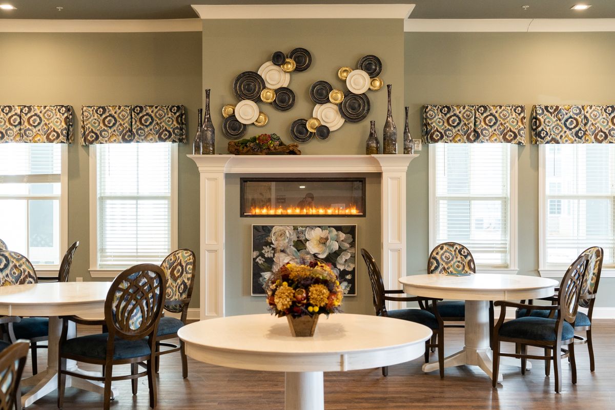 A cozy living room featuring a decorative fireplace, modern wall art, and elegant furniture.