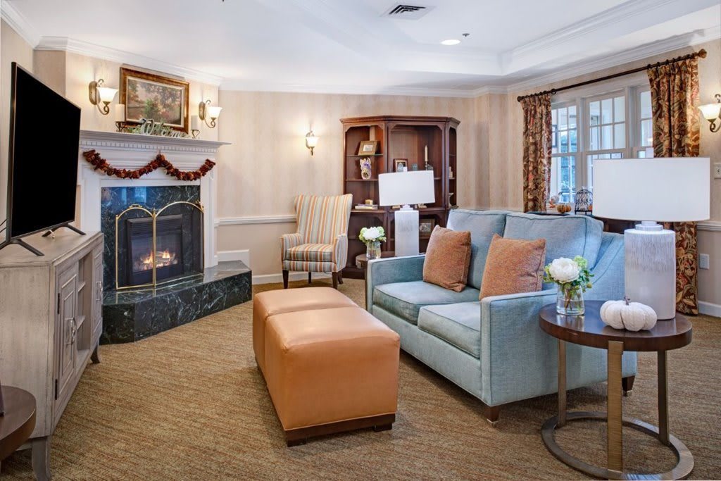 A cozy living room with a fireplace, sofa, and armchair.