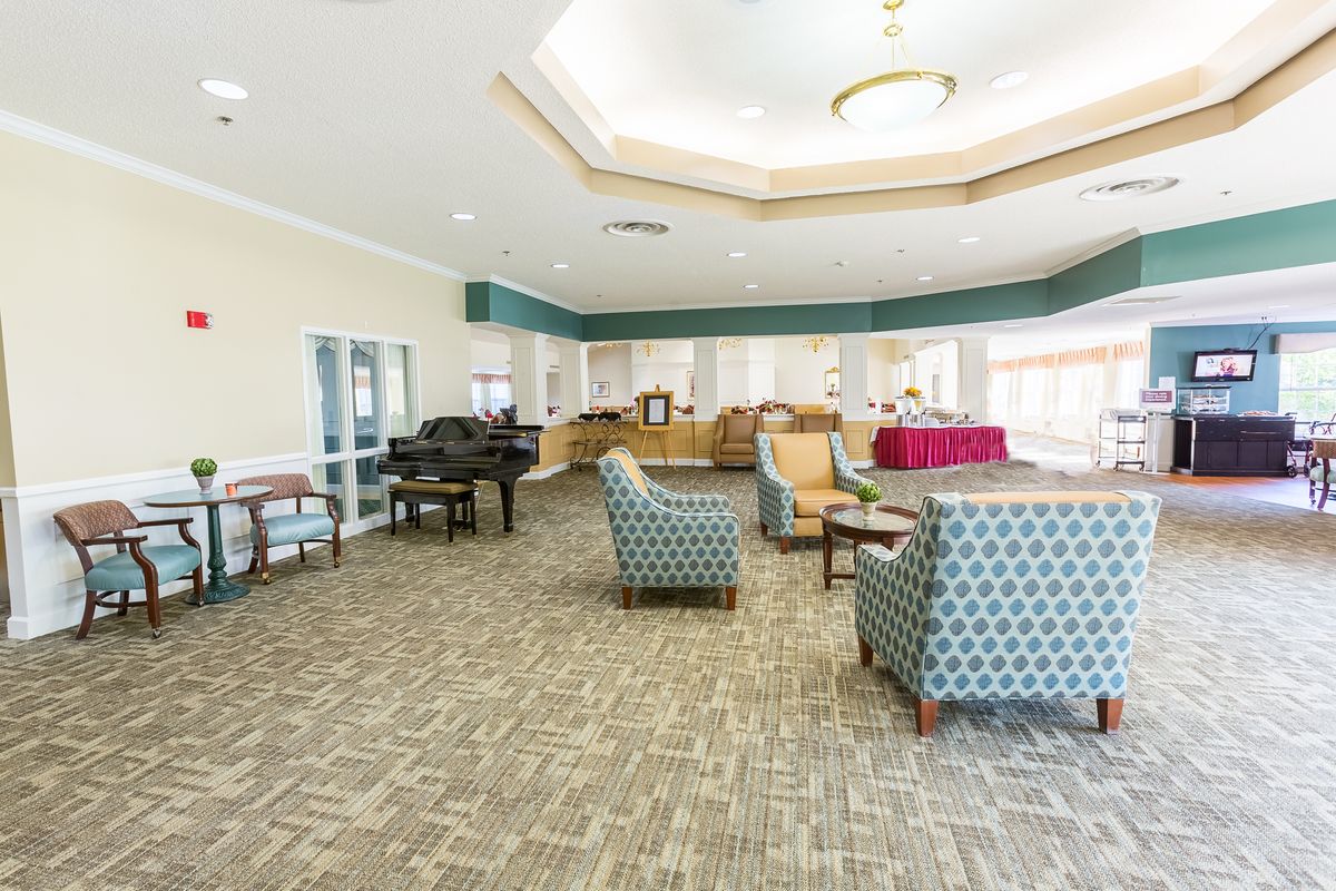 A spacious lounge area with comfortable seating and a grand piano.