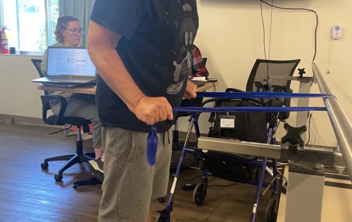 A person using a walker indoors in a rehabilitation setting.