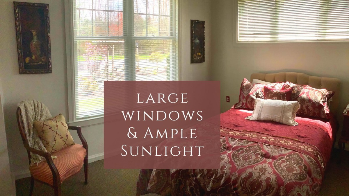 A cozy bedroom featuring large windows that allow plenty of natural sunlight.