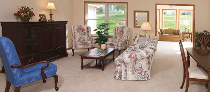 A cozy living room with floral upholstered seating and a wooden coffee table.
