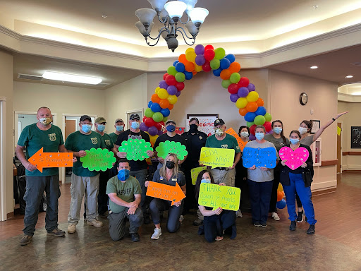 A joyful gathering celebrating a special occasion with colorful balloons and creative signs.