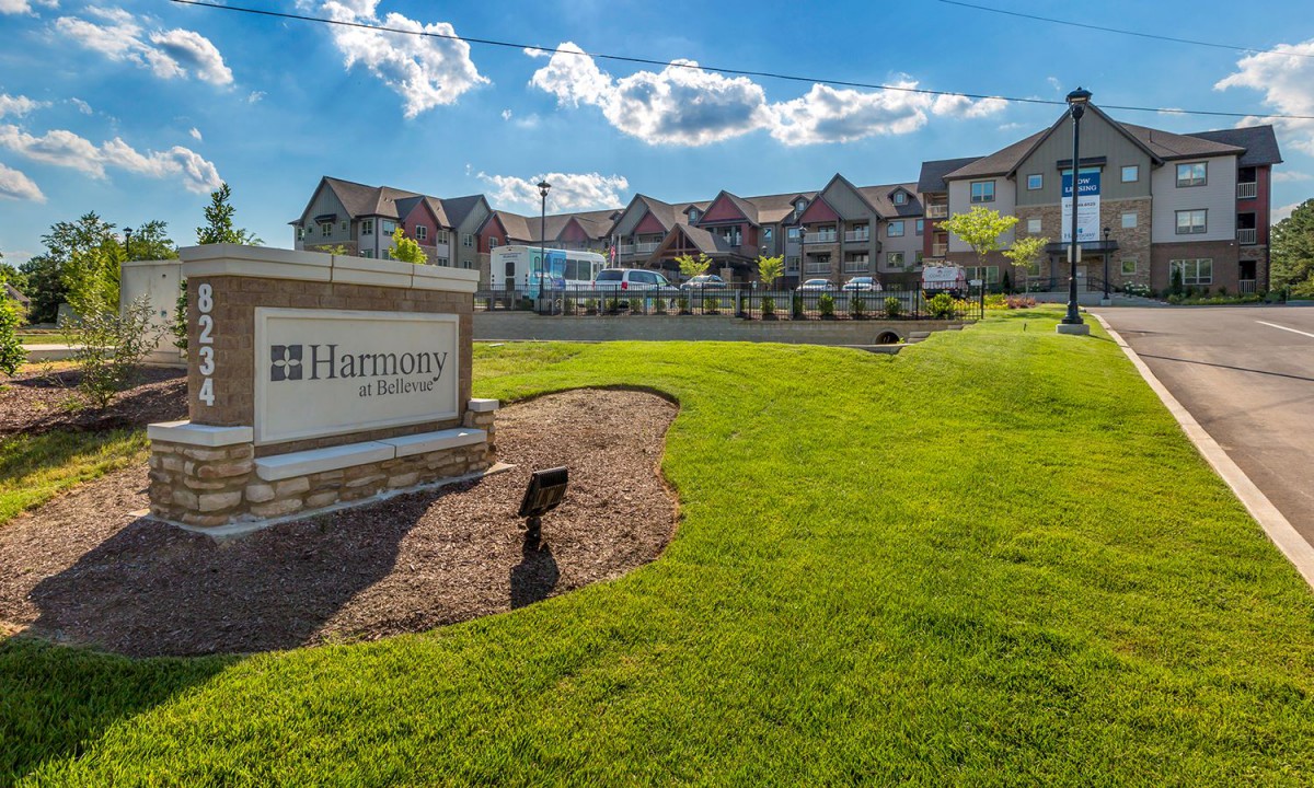 A suburban neighborhood with well-maintained landscaping and a prominent entrance sign.