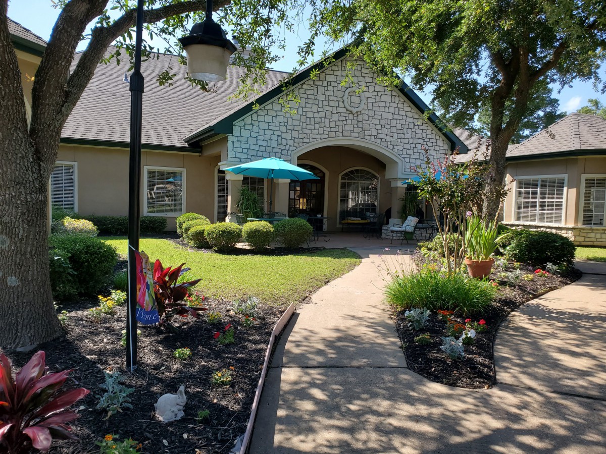 A picturesque house with a well-maintained garden and a pathway leading to the entrance.