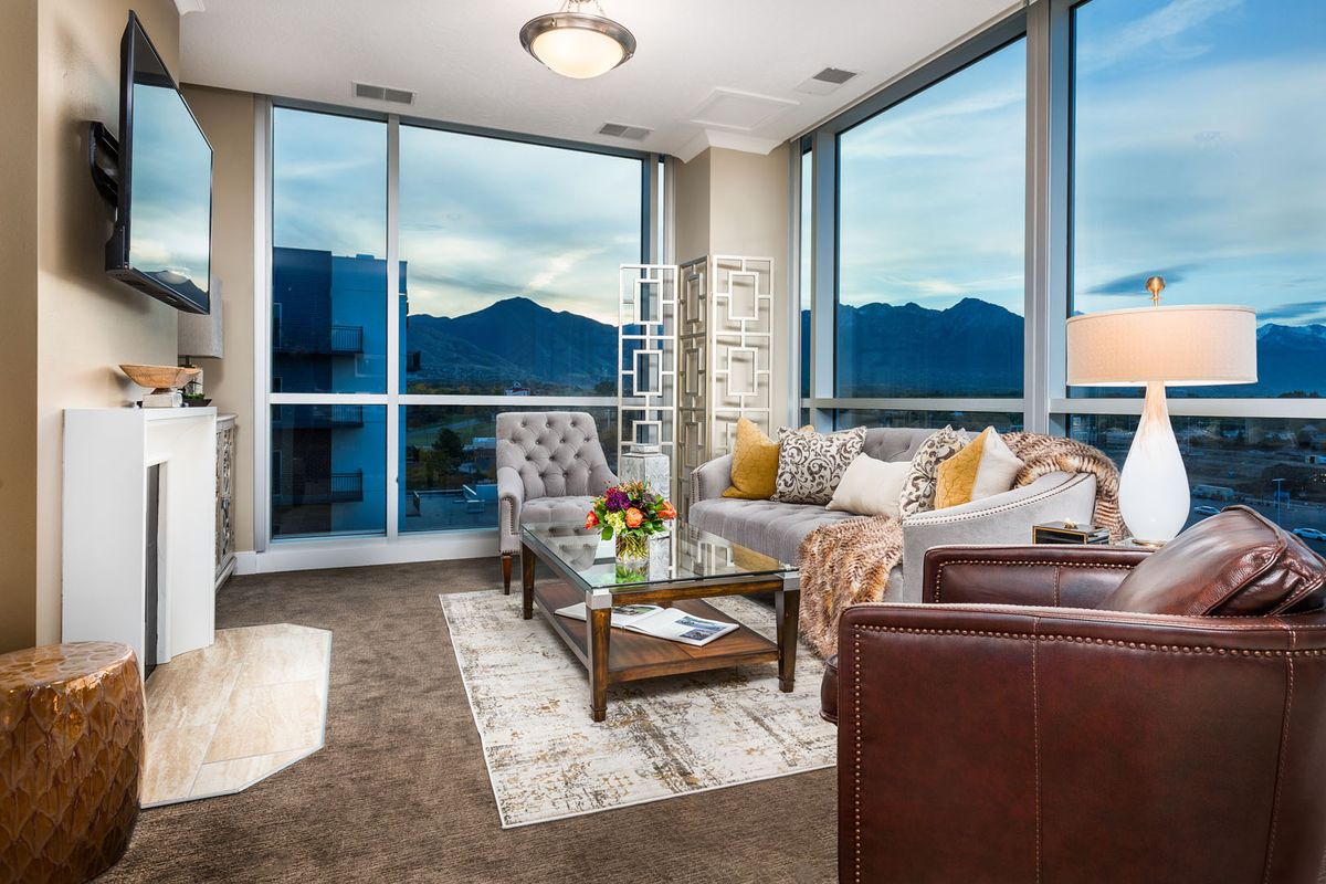 A modern living room with panoramic windows offering a stunning mountain view, decorated with stylish furniture and a cozy atmosphere.