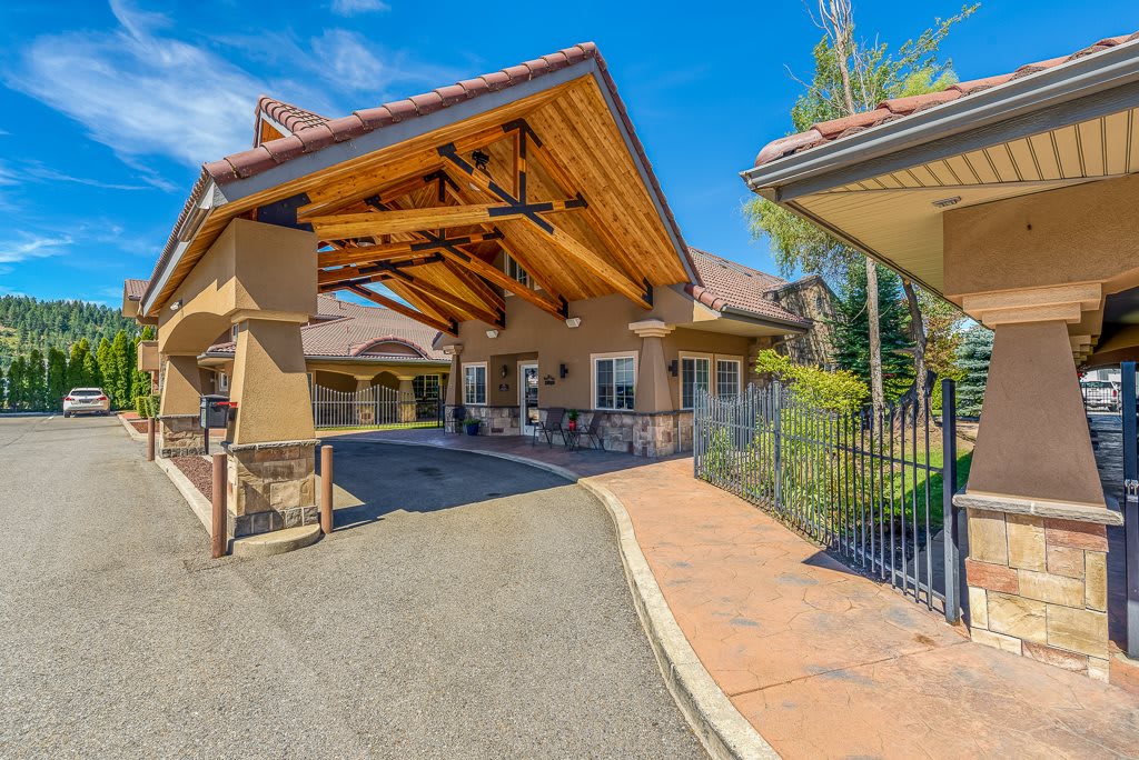 A modern building entrance with a covered driveway on a sunny day.