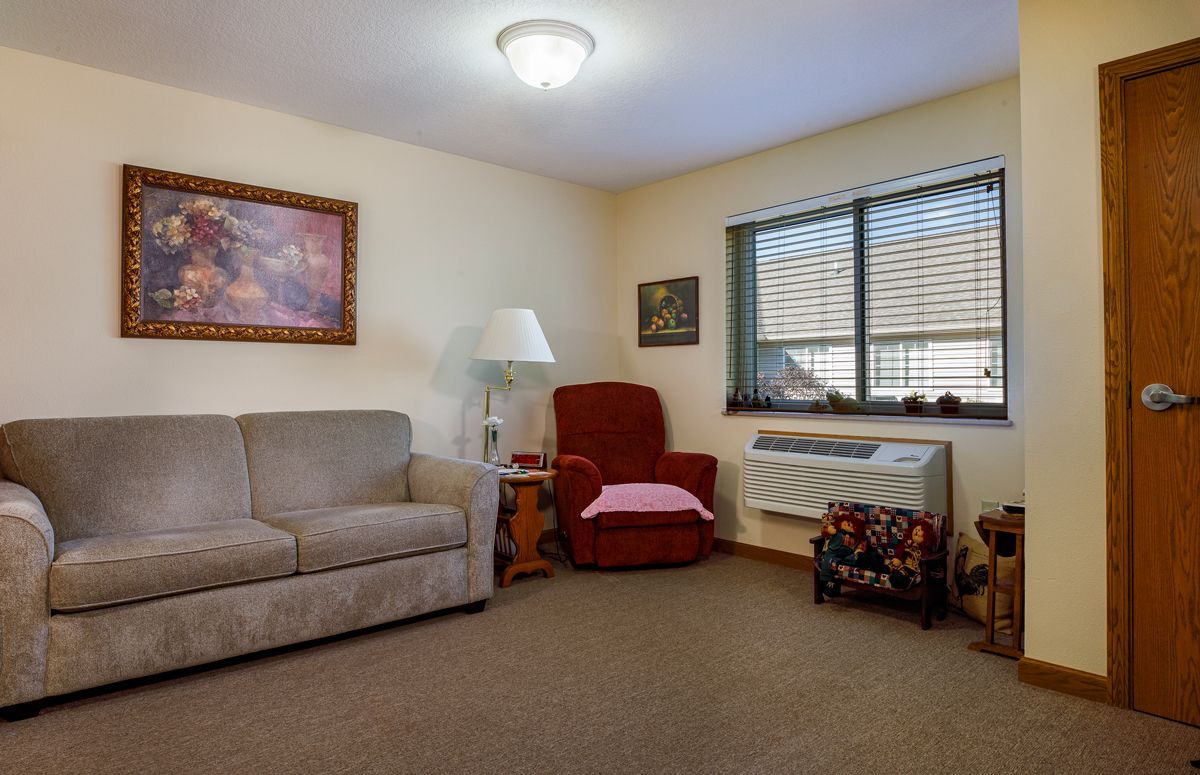 A cozy living room with a sofa, armchair, and decor.