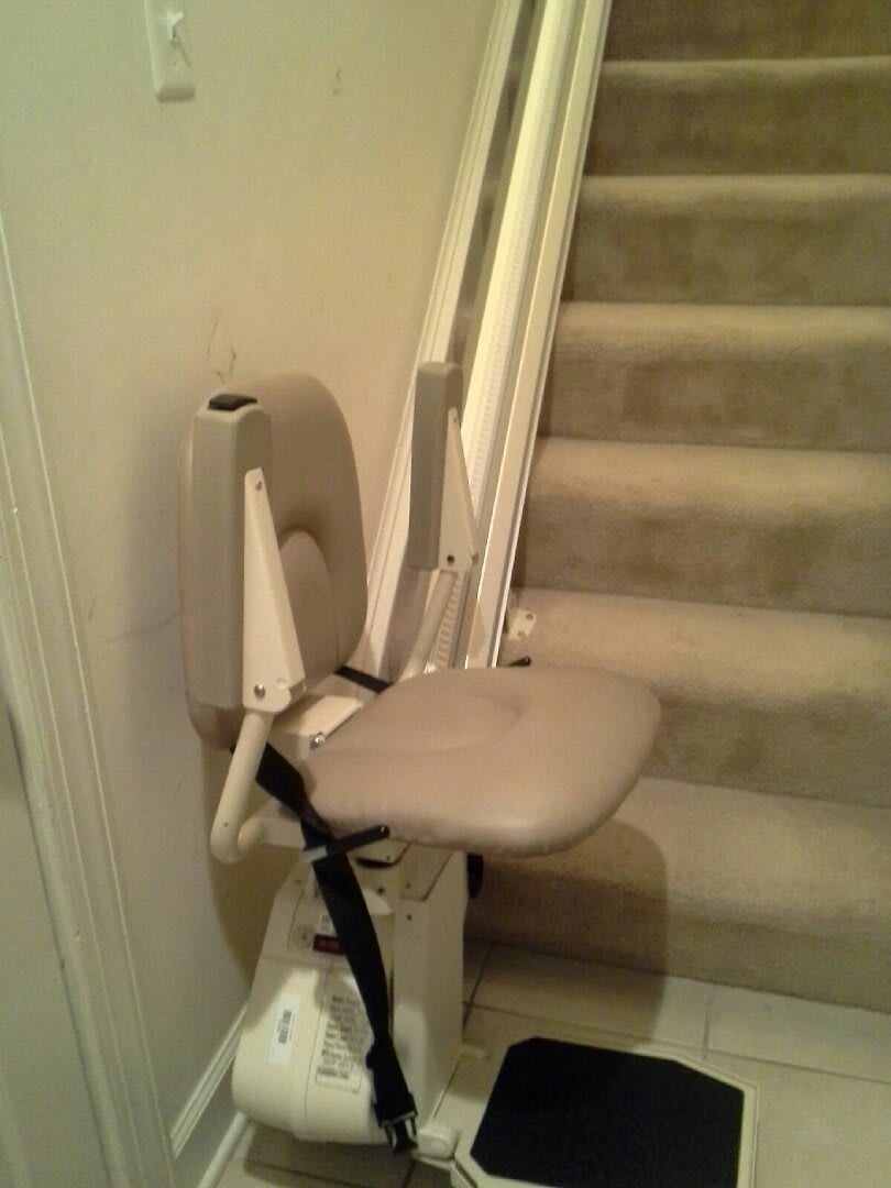 A stairlift installed next to a staircase for accessibility.