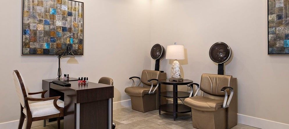 A cozy salon waiting area with chairs and a hair dryer.