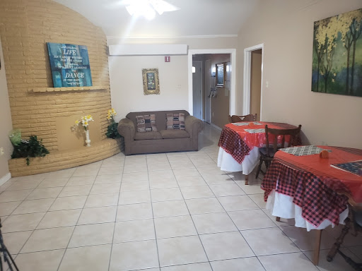 A cozy living room featuring a couch and two tables adorned with checkered tablecloths.