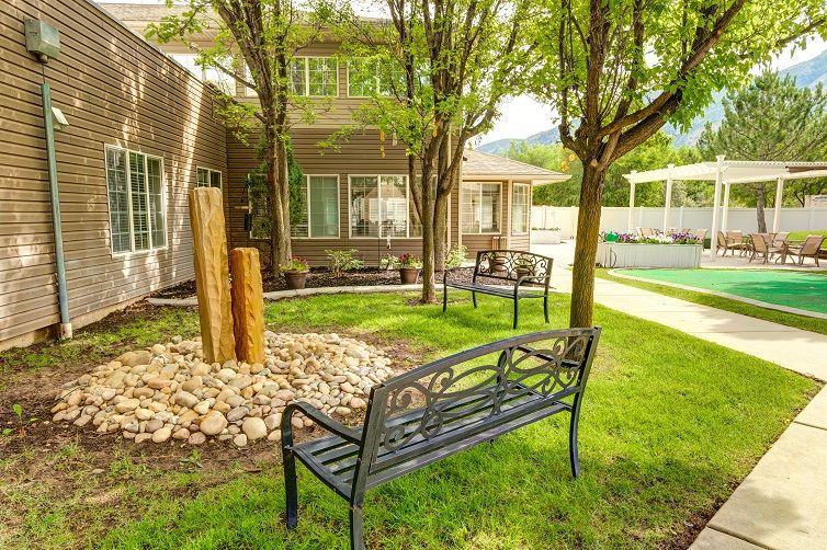 A peaceful garden area featuring benches, trees, and well-maintained landscaping.