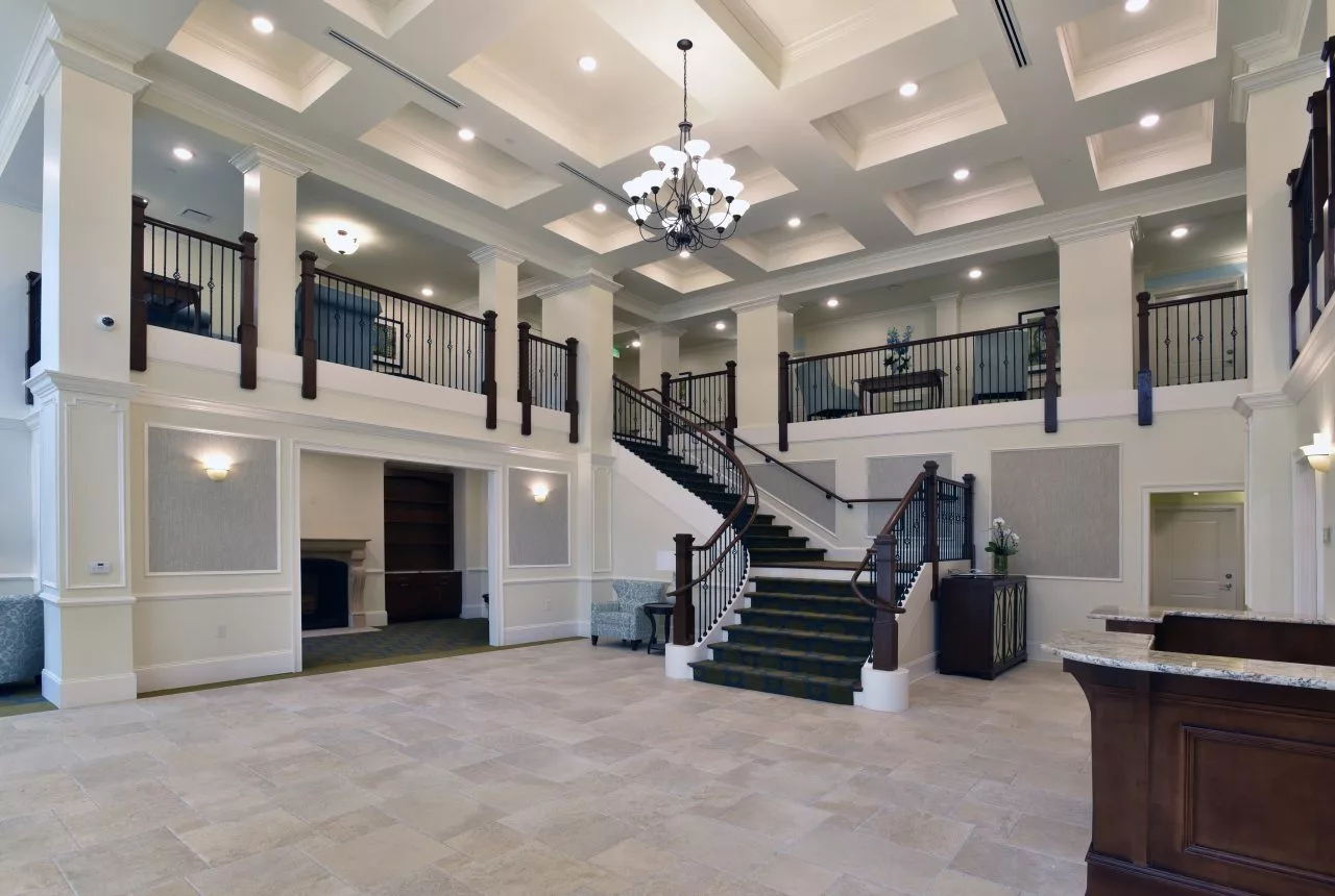 A spacious lobby with a grand staircase and elegant chandelier.