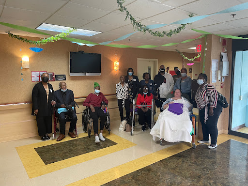 A joyful gathering of residents and staff at the senior care facility, celebrating community and companionship.