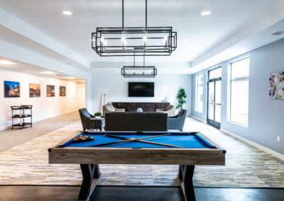 A modern game room featuring a stylish pool table and contemporary seating area.