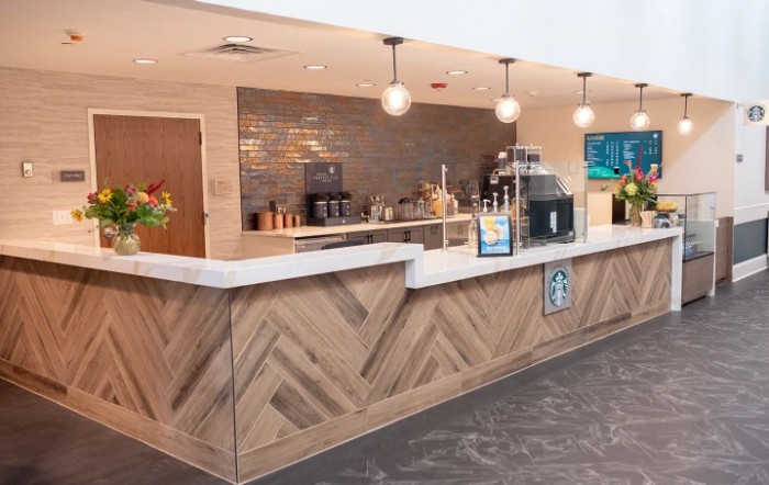 A modern cafe counter with stylish lighting and beverage equipment.