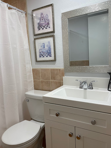 A neatly designed bathroom featuring a modern sink, toilet, and decorative wall art.
