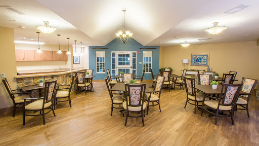 A well-lit dining area featuring wooden tables and chairs, designed for a comfortable dining experience.