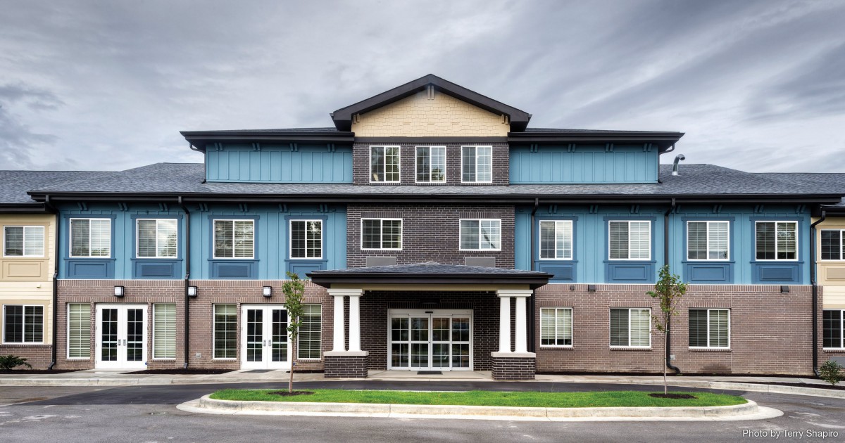 A modern residential building with a mix of brick and siding exterior.