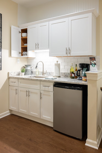 A modern kitchen featuring white cabinetry, a sleek sink, and a stainless steel dishwasher.