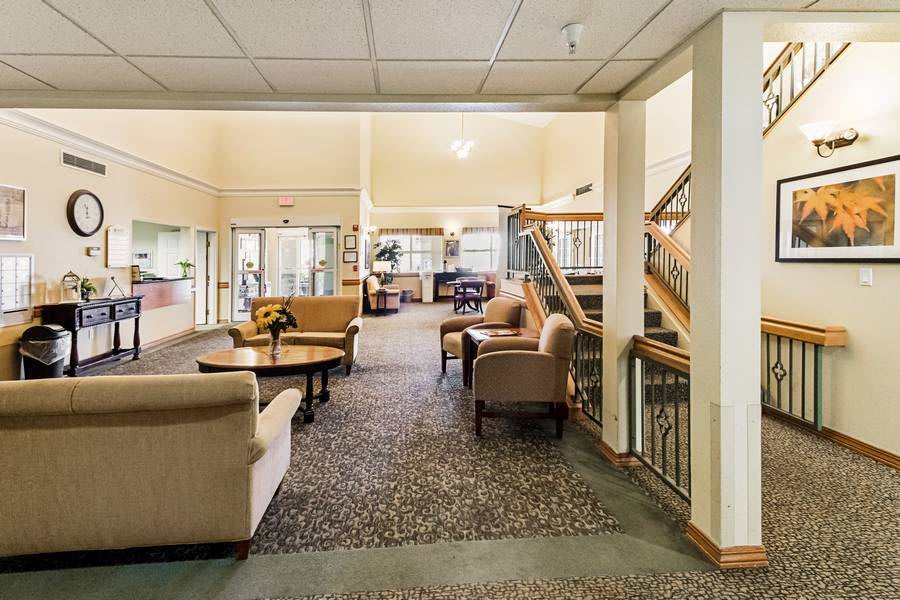 A spacious lobby with seating arrangements and a staircase.