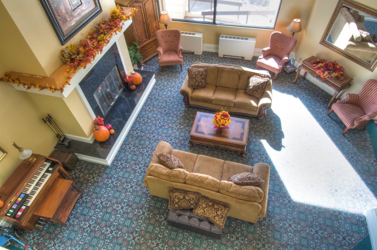 A cozy living room featuring fall decorations, two sofas, and a fireplace, viewed from above.
