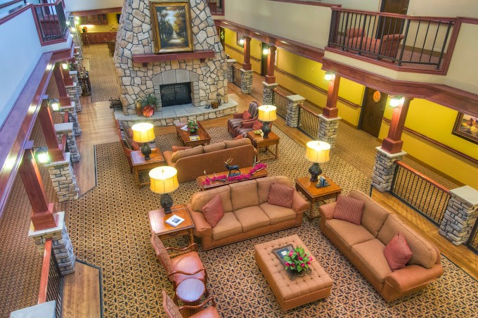 A cozy hotel lobby with comfortable seating and a stone fireplace.