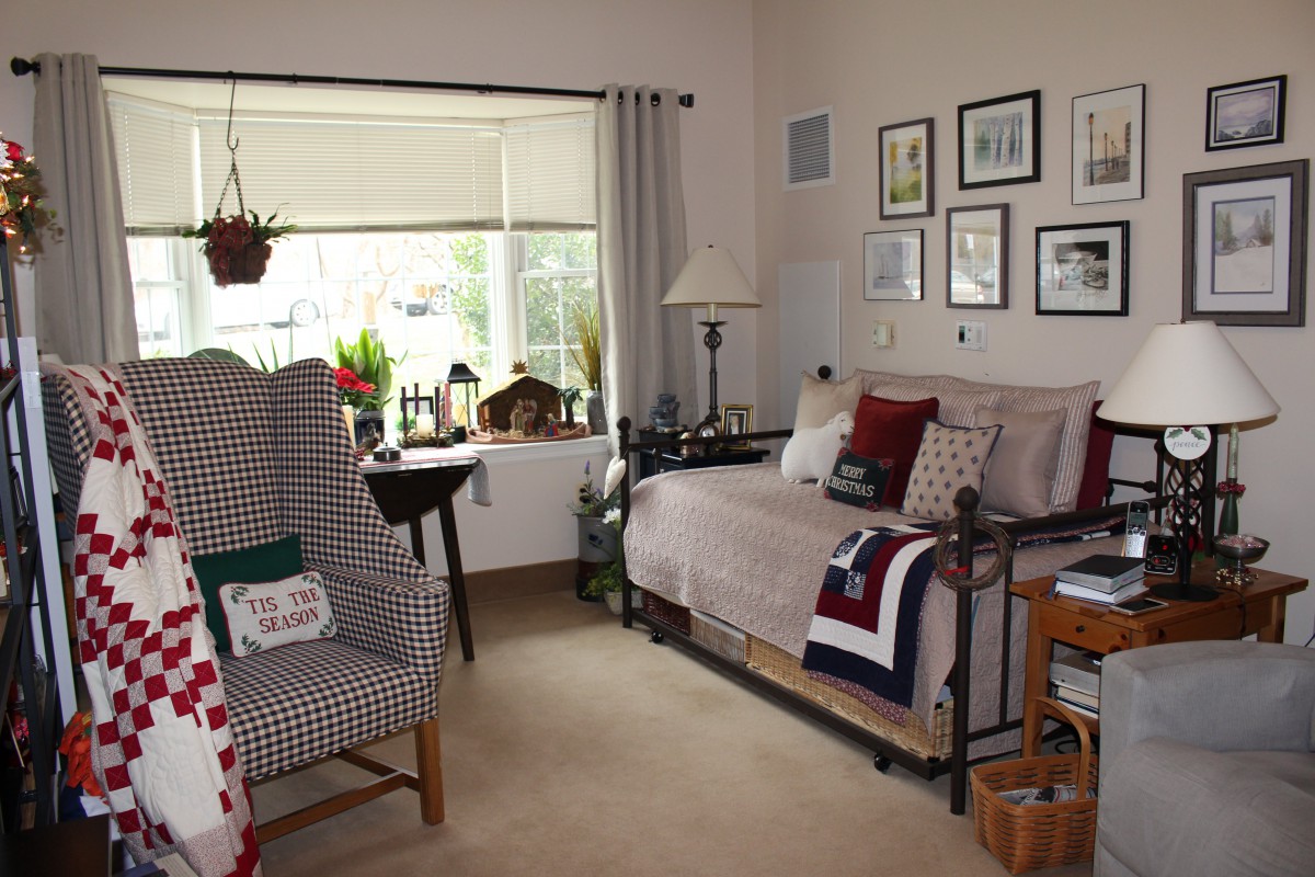 A cozy living room with a large window, comfortable seating, and decorative elements.