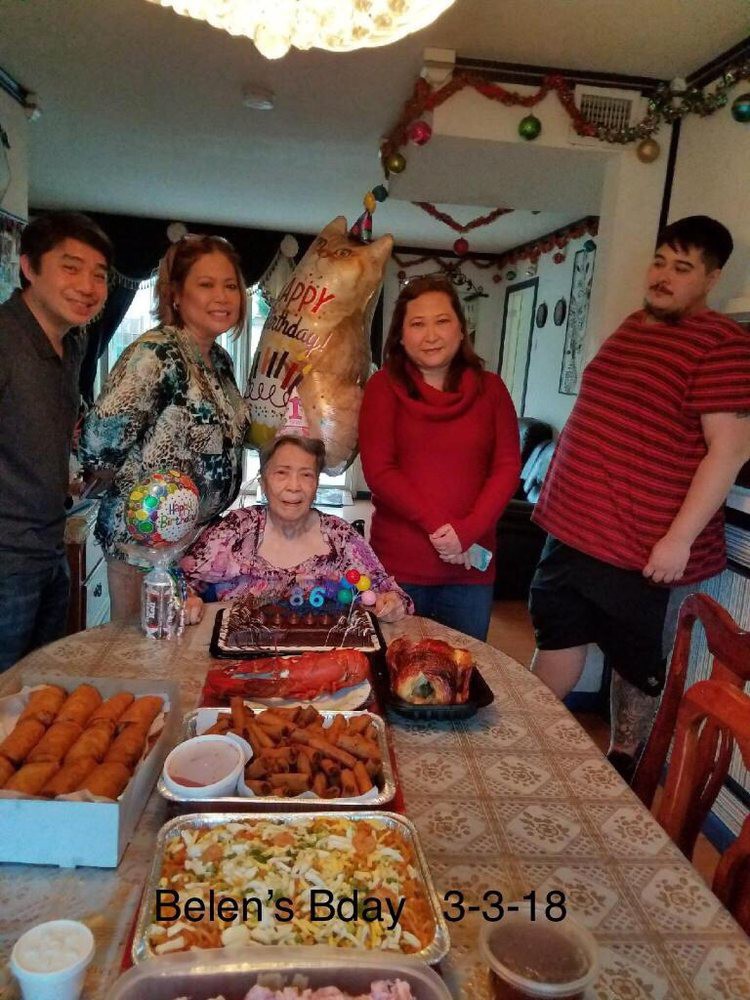 Family gathered around a birthday table with food and cake.