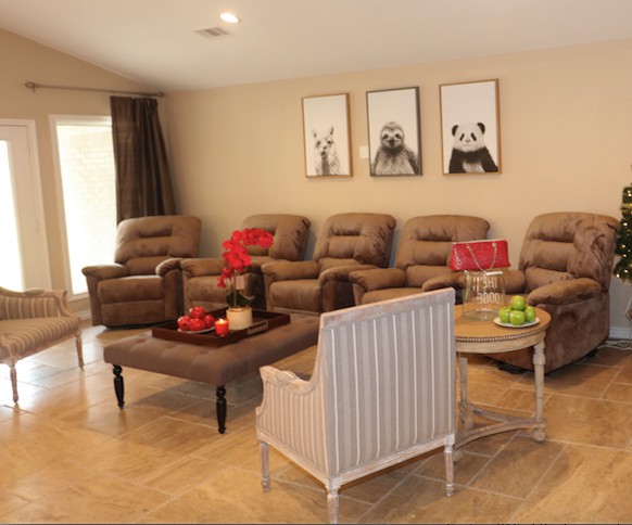 A cozy living room featuring recliner chairs, a coffee table, and wall art for a comfortable setting.