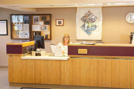 A woman at a reception desk in an office setting.