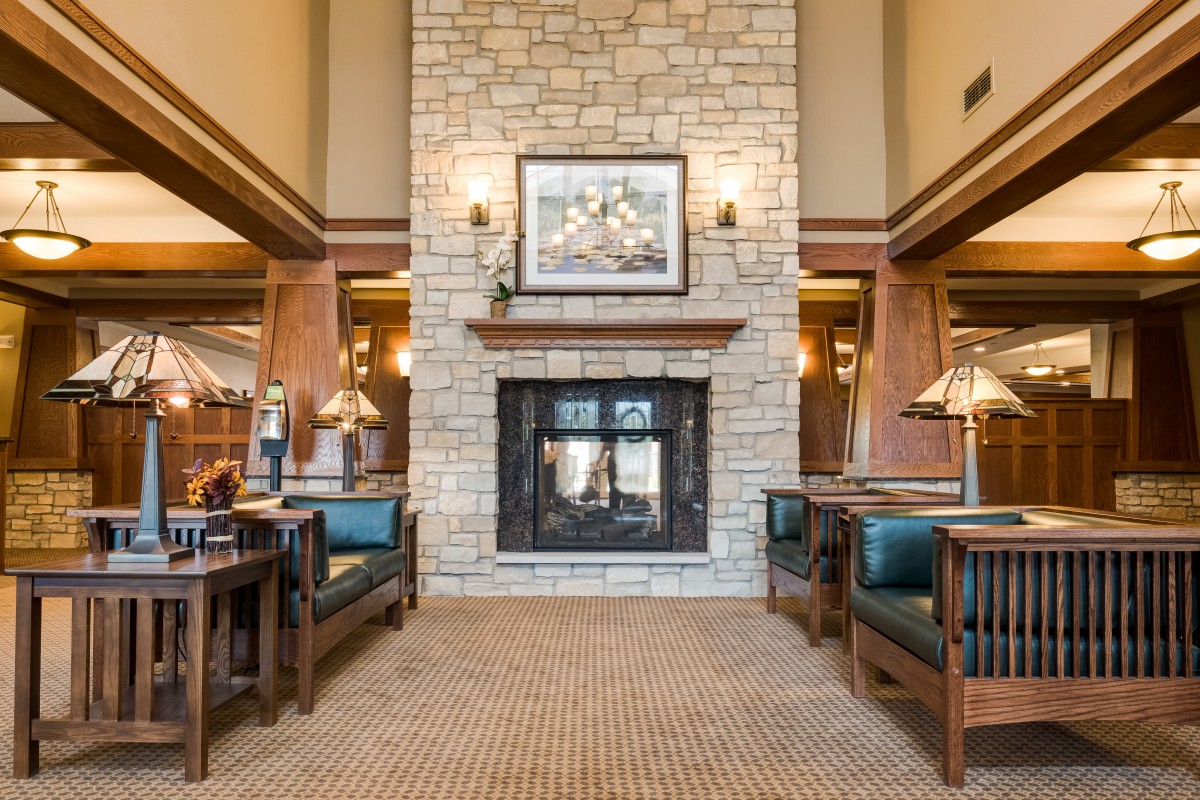 A cozy living room with a central stone fireplace and modern furnishings.